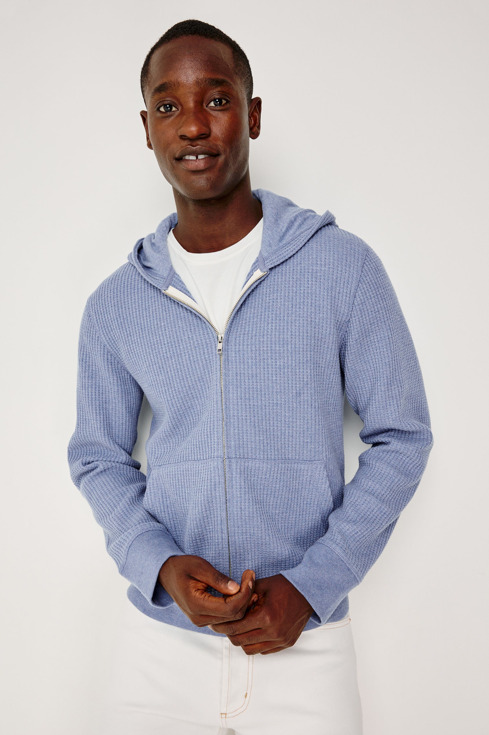 Kenton is a zip front hooded sweatshirt with front patch pockets and ribbed cuffs in Blue Heather colorway. Front view featured on model.