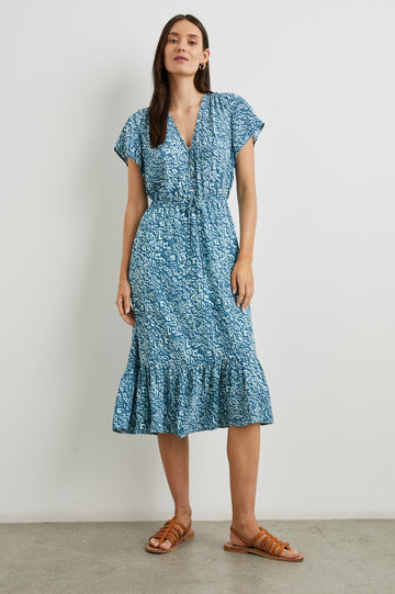 Kiki Short Sleeve Midi Dress with a V Neck, Buttons Down the Front Bodice, a Drawstring Waist and Ruffles at the Hem in Blue Havana Colorway, a Print in Blues - Front Full Body View Featured on Model 