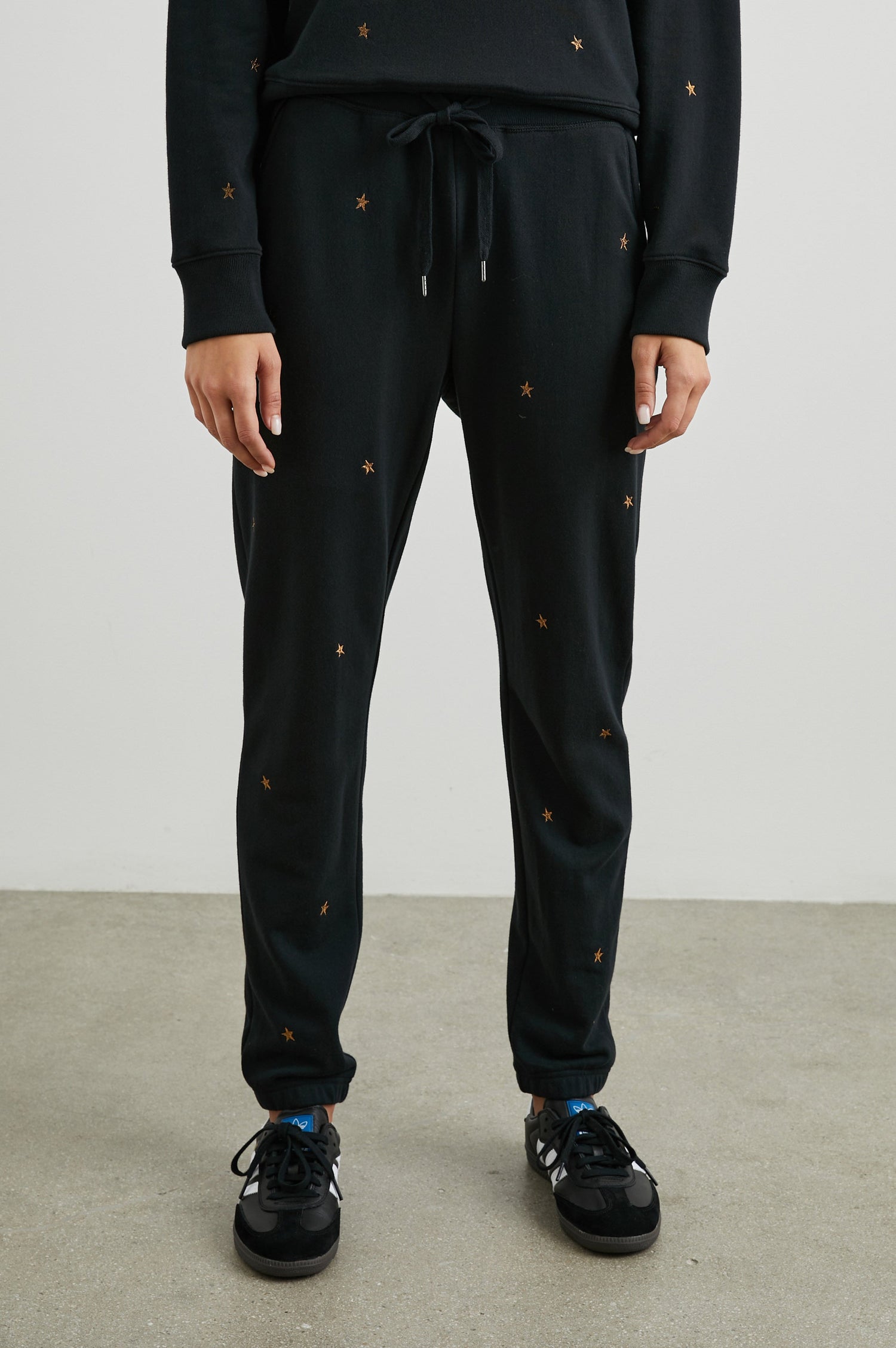 Kingston Sweatpants with Elastic Cuffs and Waist with Drawcord in Bronze Star Embroidery Colorway, Bronze Stars on Black - Front View Featured on Model
