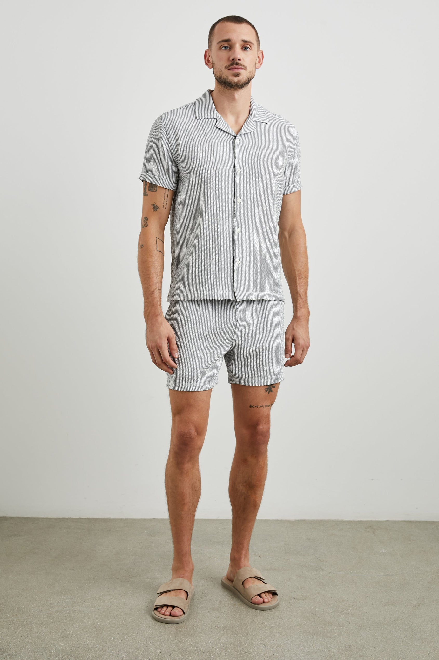 La Brea Swim Shorts with a Drawstring Waist, Two Front Pockets and a Back Patch Pocket in Faded Seersucker Colorway, Grey and white thin vertical stripes - Front Full Body View Featured on Model