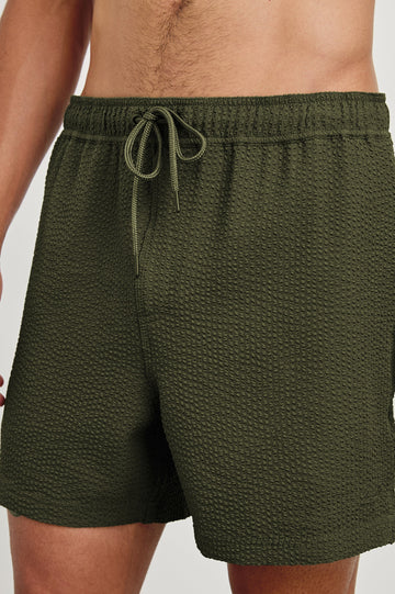 La Brea textured mid-length swim short with adjustable waist drawstring in Olive Seersucker - close up of details on model
