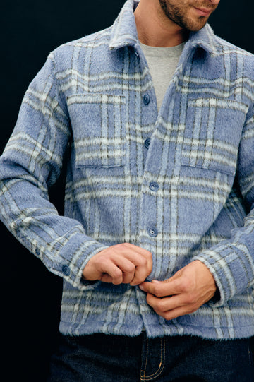 Lachlan is a fully lined shirt jacket with a classic collar, front buttons, chest patch pockets in Blue Lotus colorway. Front detail view featured on model.