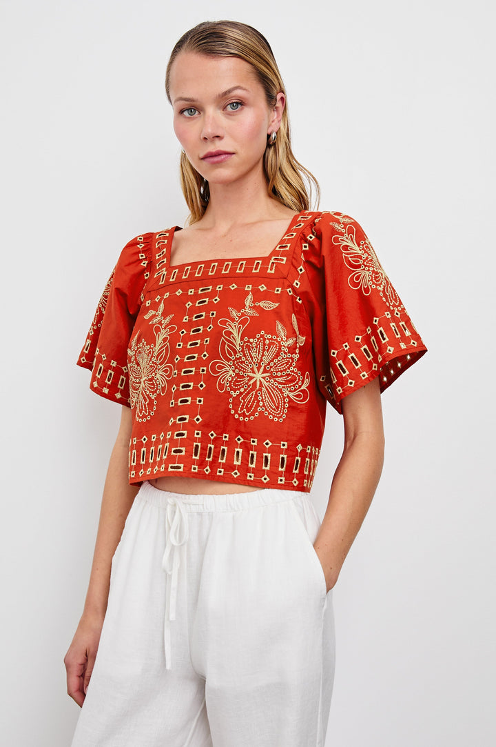 Laine airy cotton poplin top with wide short sleeves and a loose fit. Contrast eyelet embroidery in color Terracotta - front view on model