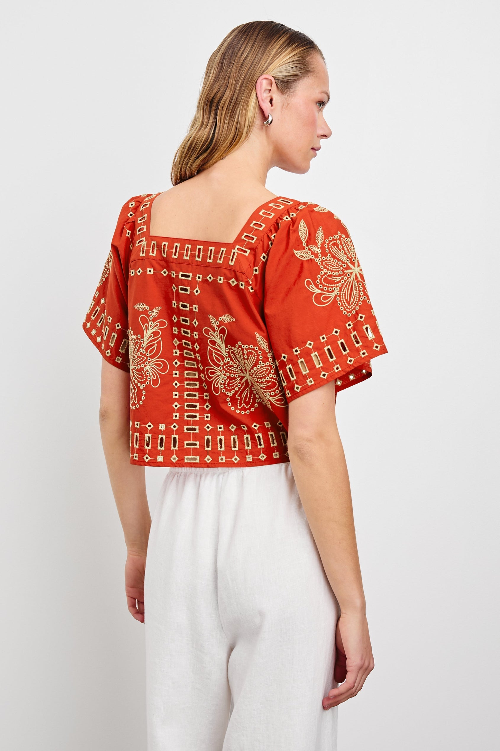 Laine airy cotton poplin top with wide short sleeves and a loose fit. Contrast eyelet embroidery in color Terracotta - back view on model
