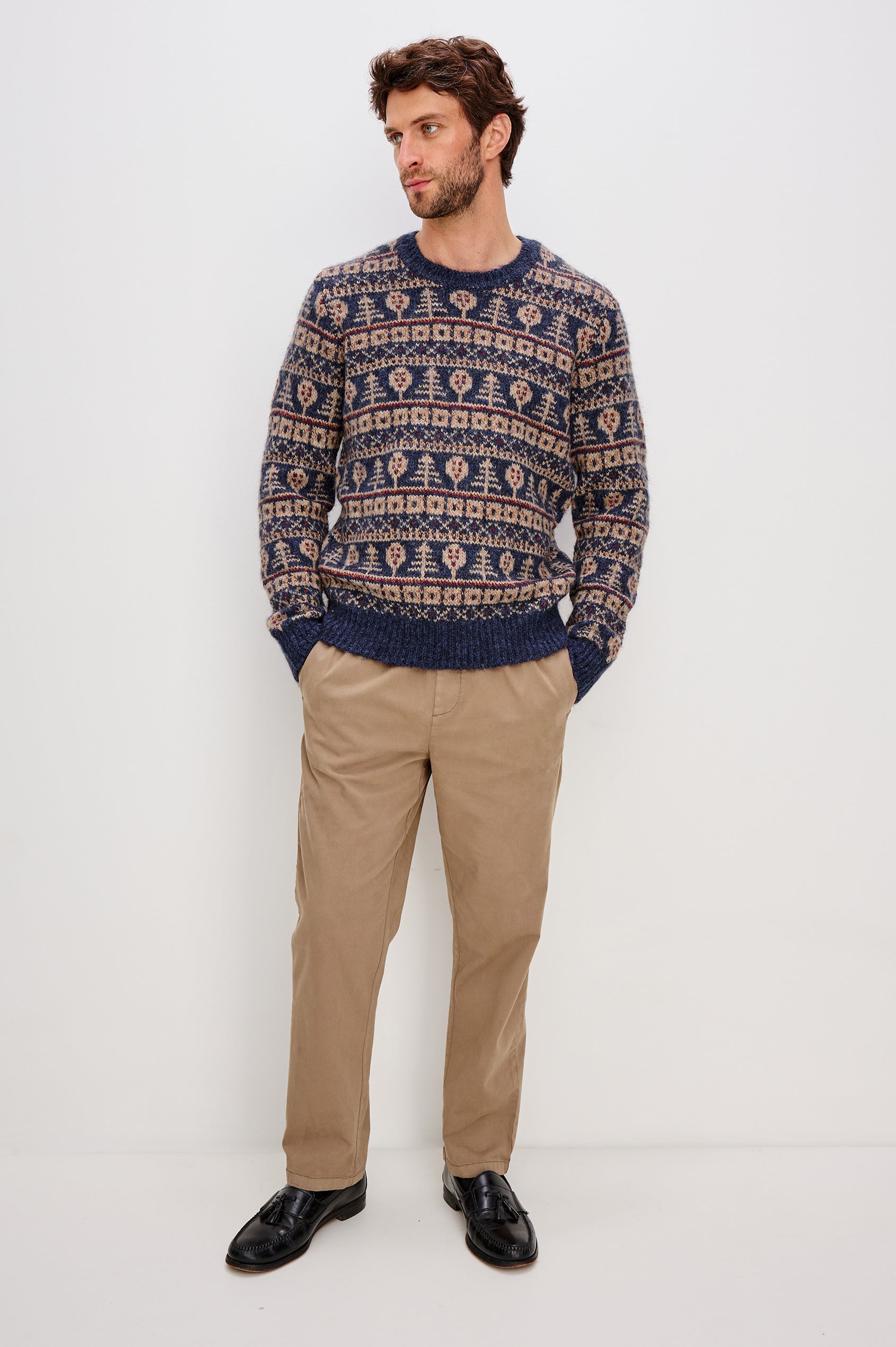 Lars is a relaxed fit crewneck sweater with long sleeves and ribbed trim, Fair Isle motifs in a merino wool blend. Front full body view featured on model.