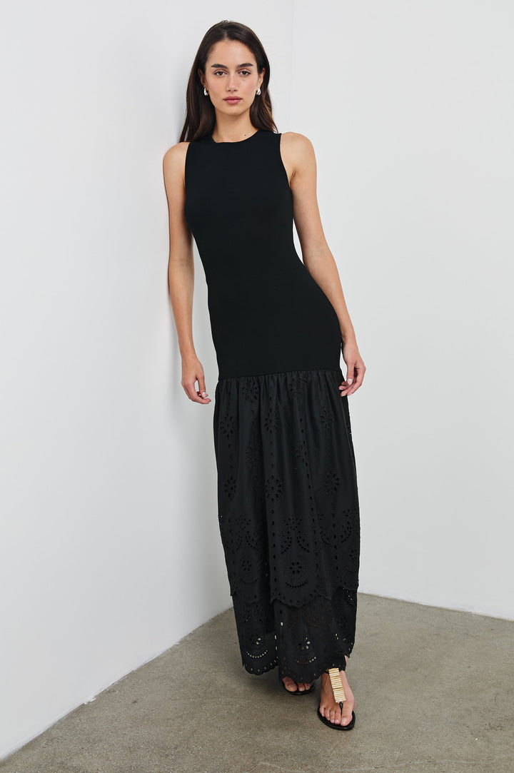 Lavina Crew Neck Maxi Dress with Body Con Fitted Top Half and an Gathered Contrast Fabric Skirt with Embroidered Scallop Hem in Black Colorway. Front View Shown on Model.