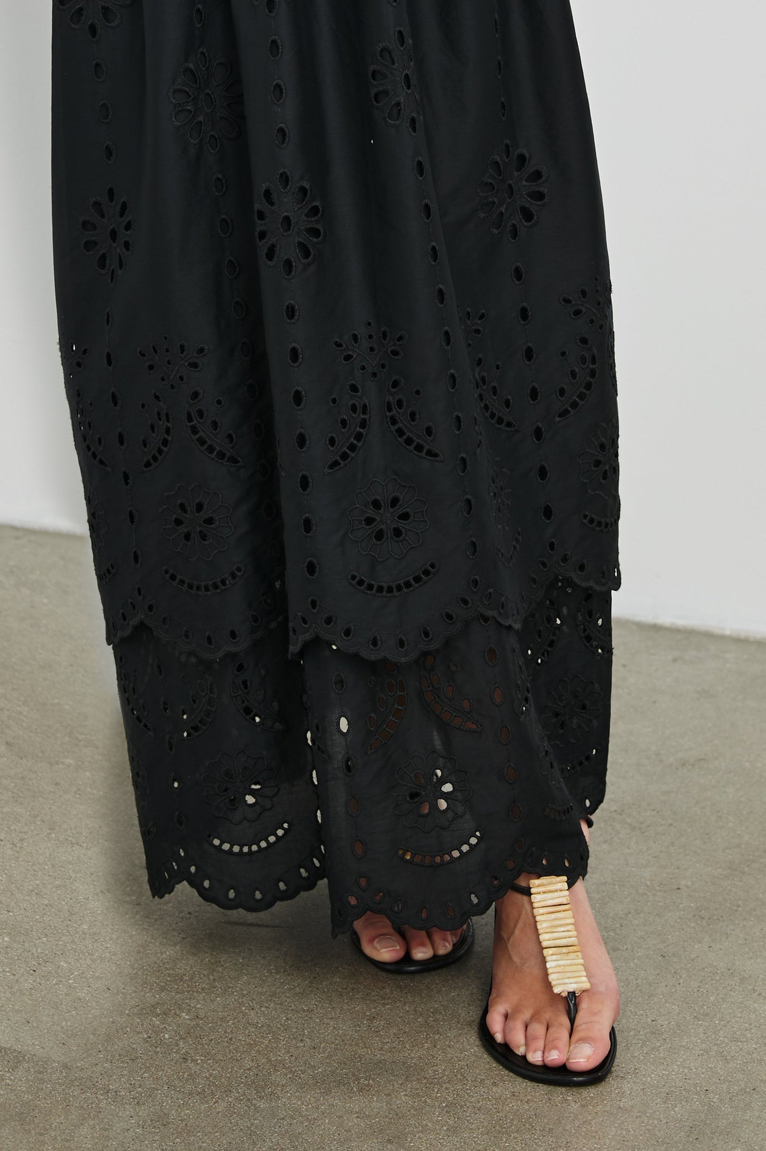 Lavina Crew Neck Tank Maxi Dress with Body Con Fitted Top Half and an Gathered Contrast Fabric Skirt with Embroidered Scallop Two Tier Hem in Black Colorway. Detailed View Shown on Model.