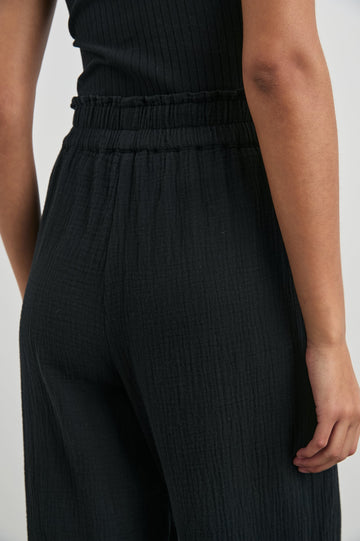 Leon Pant with a Smocked Waistband, Short Side Slits on Outer Leg and Two Front Seam Pockets in Black Colorway - Back View Featured on Model