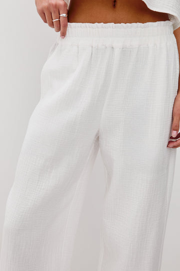 Leon Crop Cotton Gauze Pant With Hemline Slit And Elastic Waist In Colorway White - Front Detail View Featured On Model