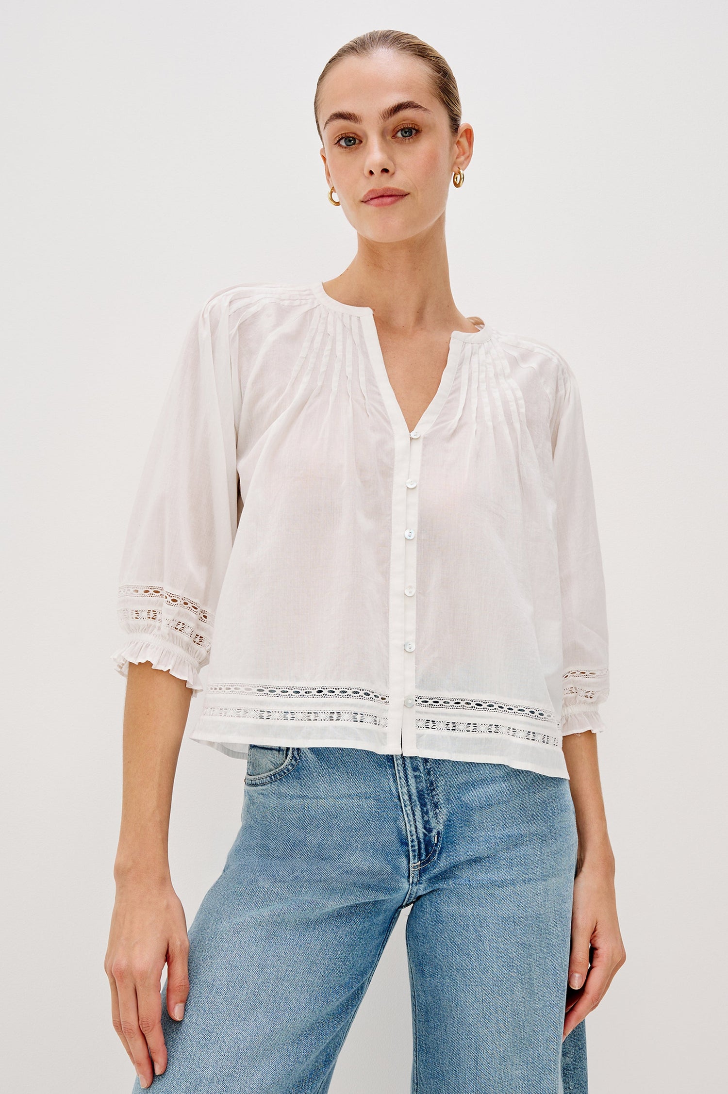 Lilah Blouse with Elbow Length Sleeves, Elastic and Gathering at Sleeve Hem, V-Neck and 3-button Front, White Lace Details at Hems in White Colorway. Front View Shown on Model.