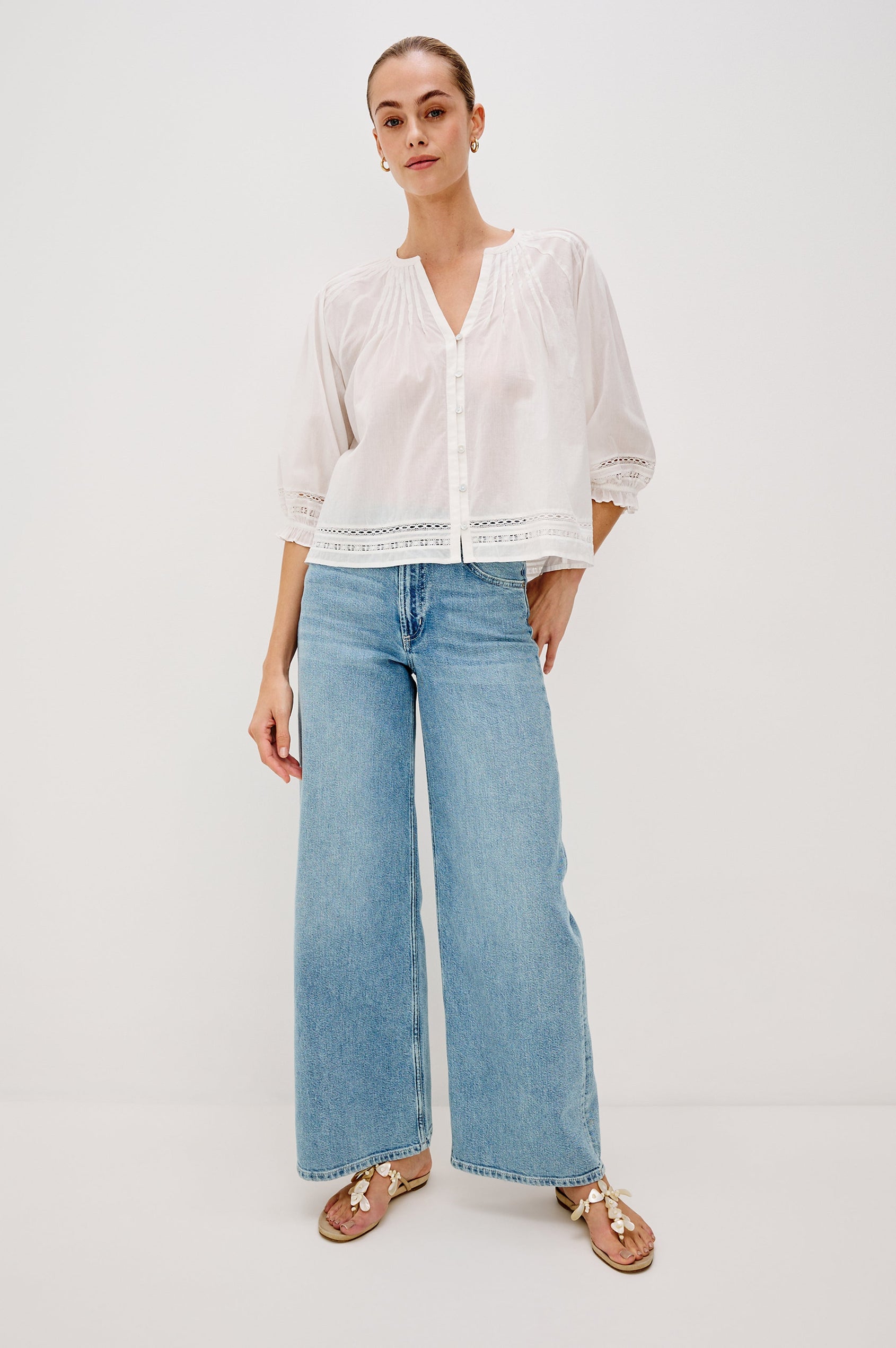 Lilah Blouse with Elbow Length Sleeves, Elastic and Gathering at Sleeve Hem, V-Neck and 3-button Front, White Lace Details at Hems in White Colorway. Full Body Front View Shown on Model.