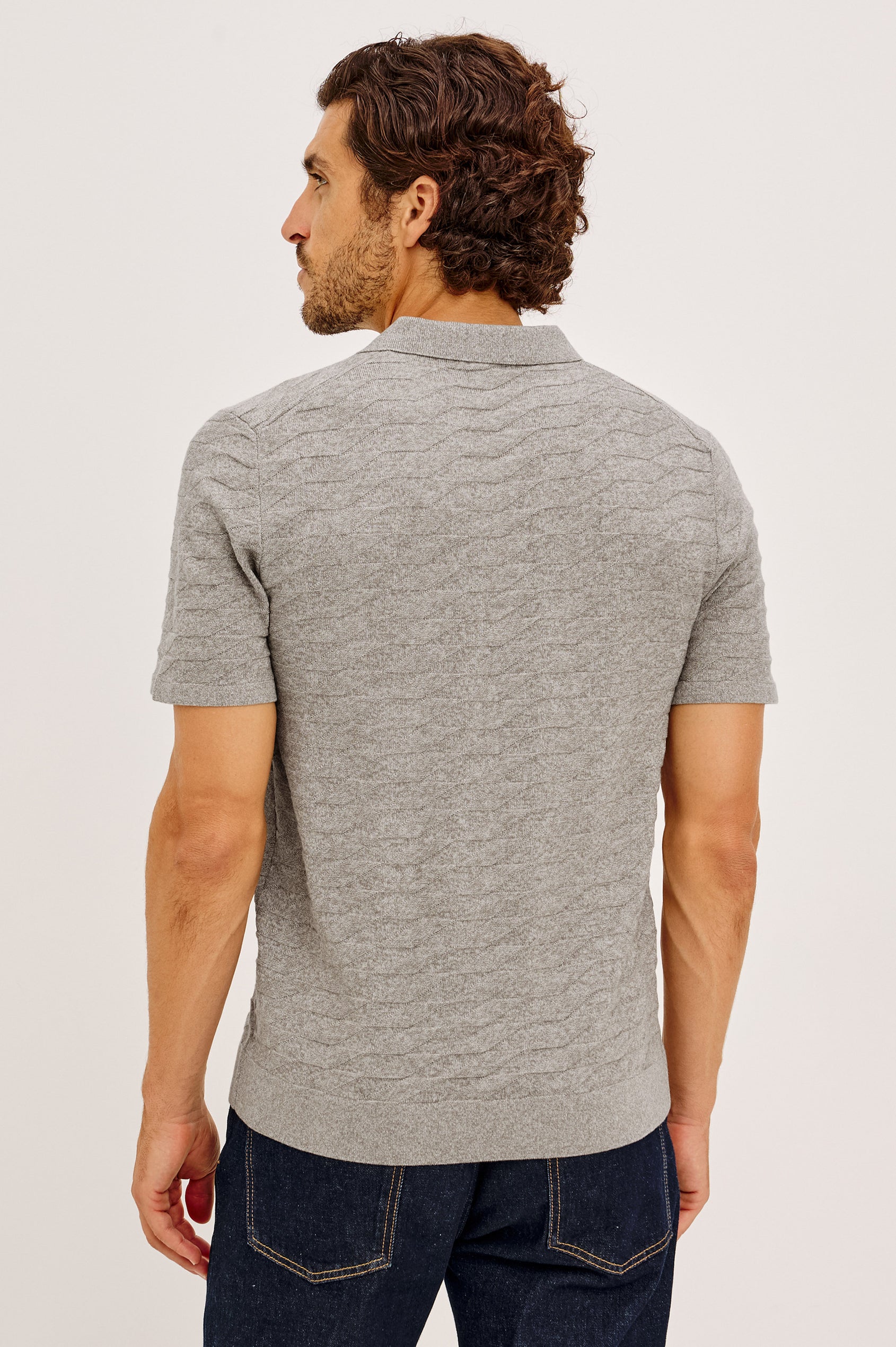Linden Polo Shirt in Cotton Knit With Subtle Diamond Texture, Classic Fit, Quarter Button Placket, Short Sleeves, and Ribbed Trim in Heather Grey Prism Colorway - Upper Body Back View Featured on Model