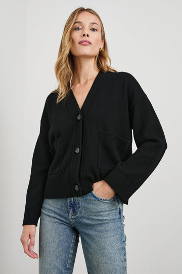 Lindi Long-Sleeve V Neck Cardigan with Three Button Closure, Two Front Patch Pockets and Ribbed Trim in Black Colorway - Front View Featured on Model