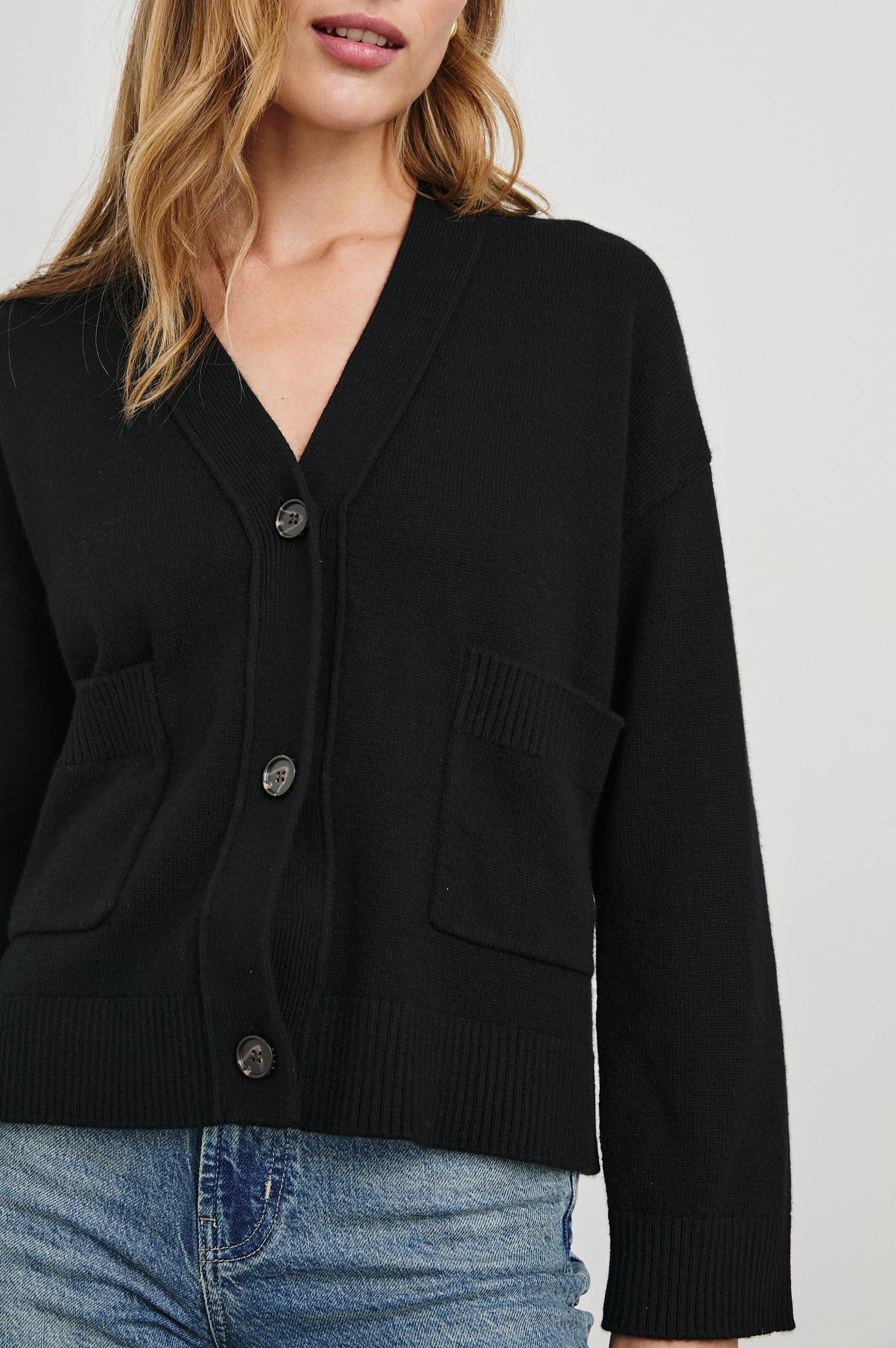 Lindi Long-Sleeve V Neck Cardigan with Three Button Closure, Two Front Patch Pockets and Ribbed Trim in Black Colorway - Front View Featured on Model