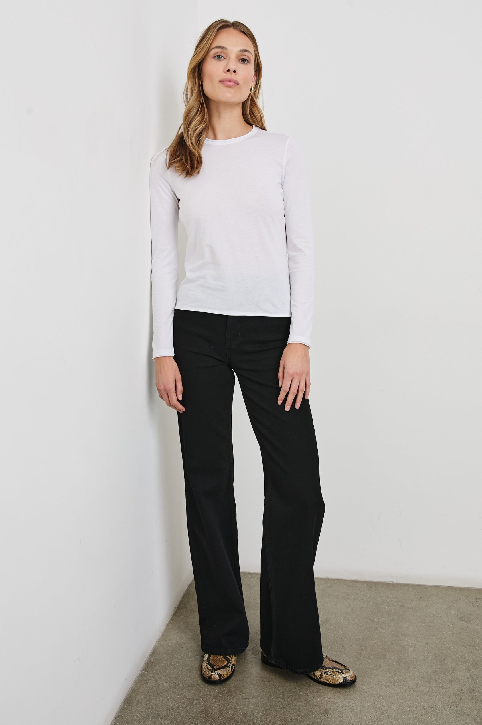 Long Sleeve Crew Neck T Shirt with Raw Hem, Collar and Cuffs in White Colorway - Front Full Body View Featured on Model