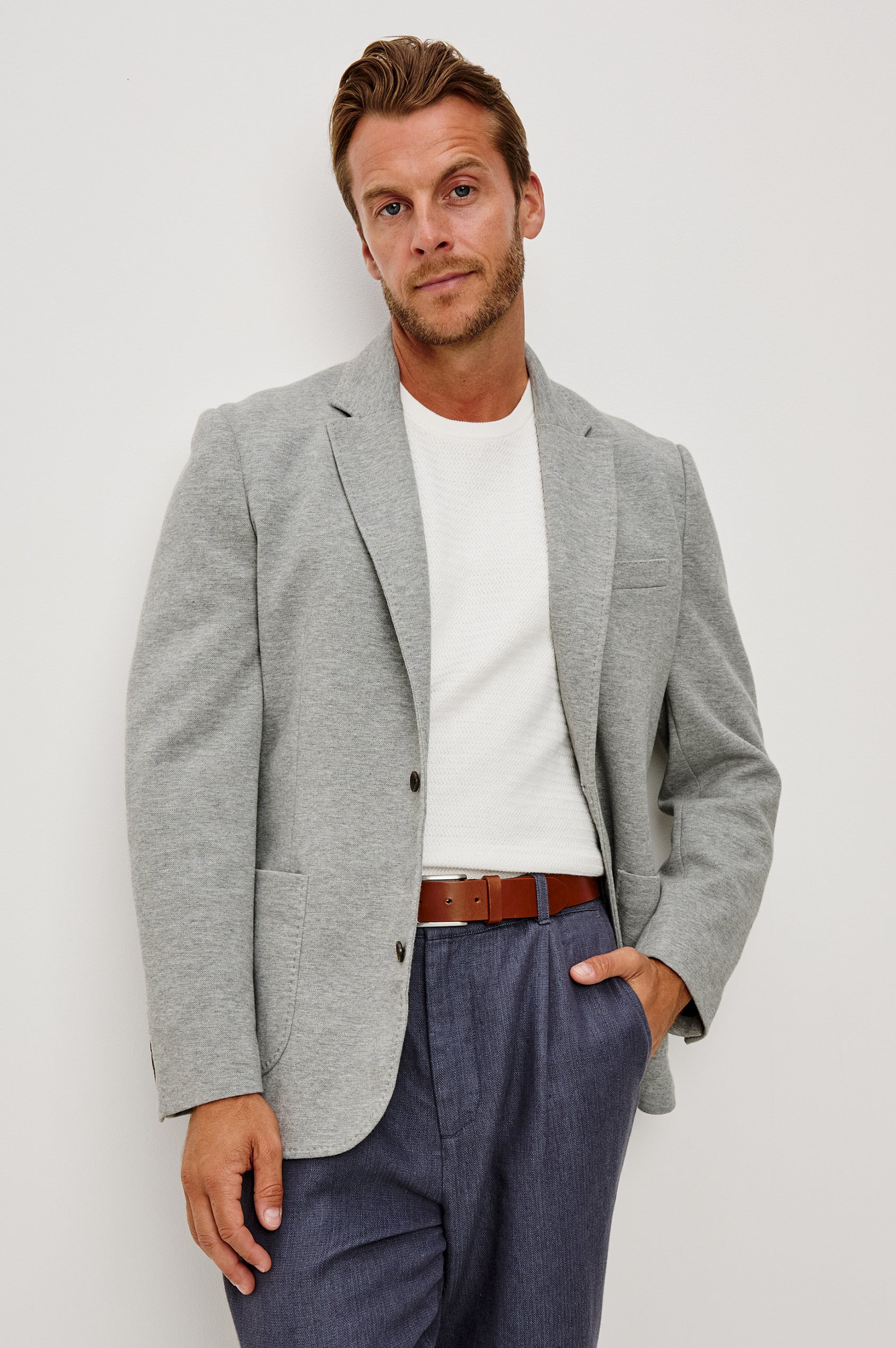 Lorenz Blazer in Cotton Blend With Notched Lapels, Long Sleeves, Front Buttons, Chest Pocket, and SIde Patch Pockets in Heather Grey Colorway - Upper Body Front View Featured on Model
