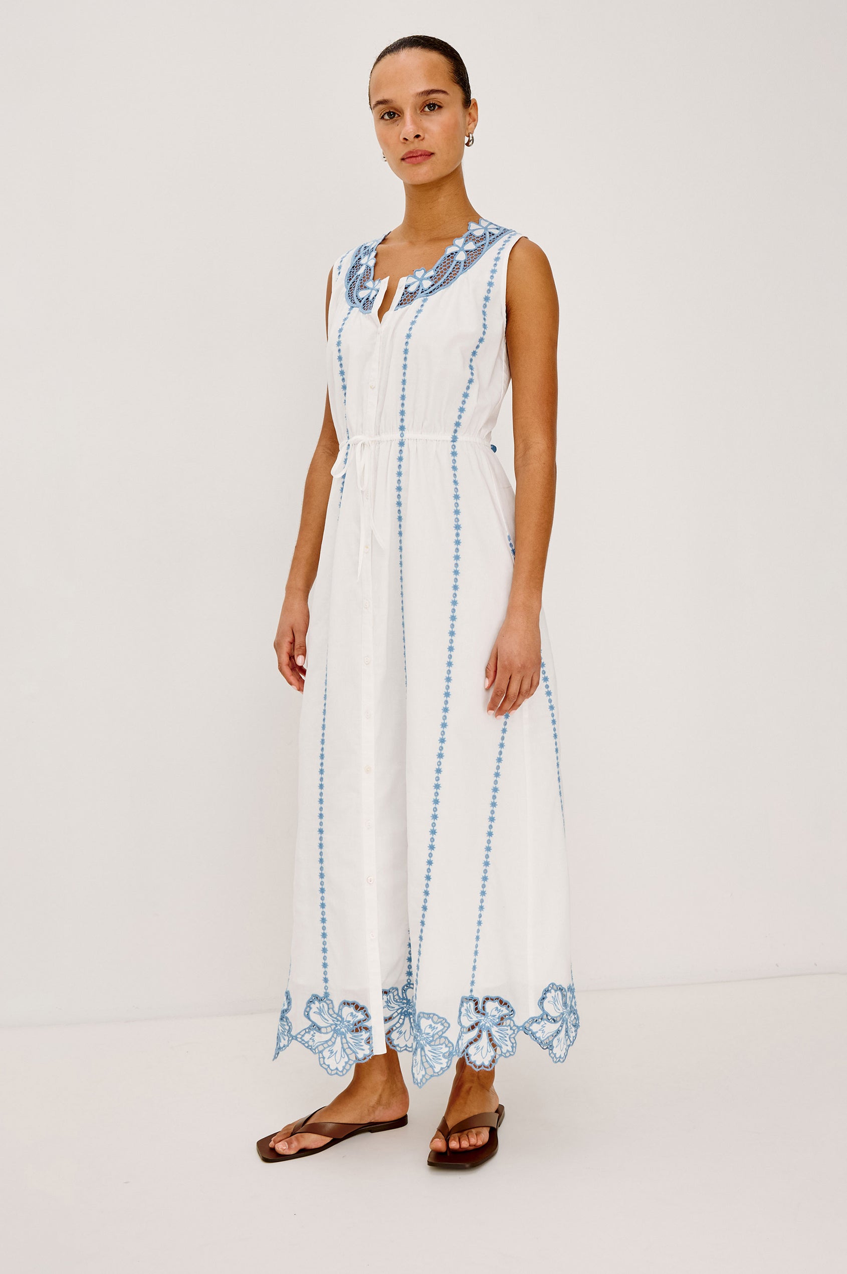 Lorina Midi Dress in Cotton Voile With Contrast Lattice and Floral Embroidery, Sleeveless Cut, and Adjustable Waist Ties in White Colorway - Full Body Front View Featured on Model