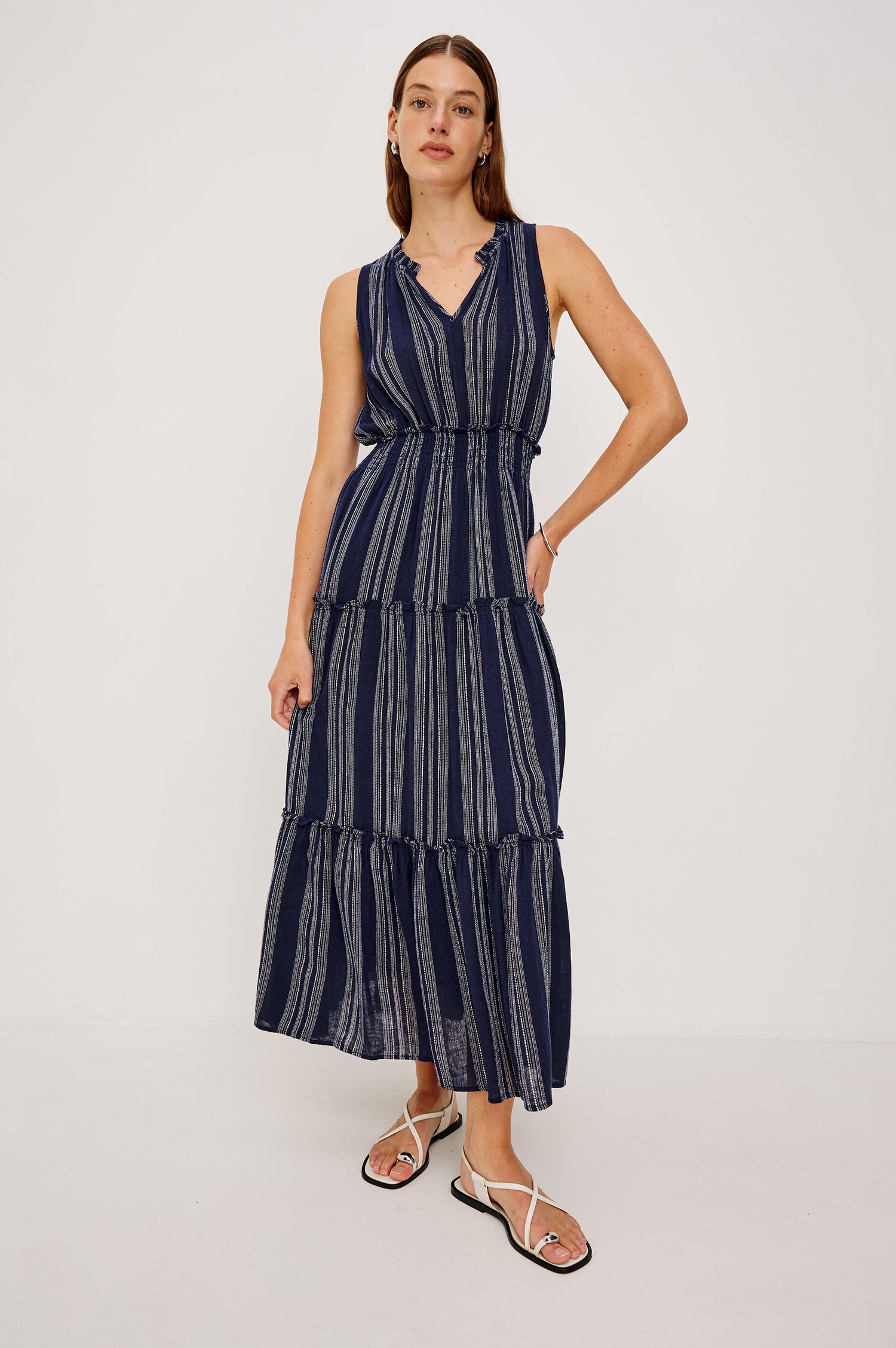 Loulou V-Neck Midi Dress with Smocked Elastic Waistband and a Multi Tiered Skirt in navy blue Magalia Stripe Colorway. Full body front view featured on model