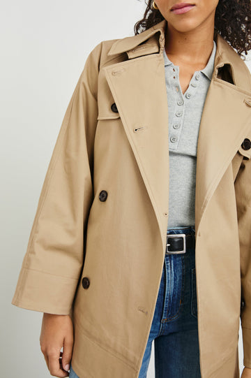 Lucien Trench Jacket with a Belt at the Waist, Button Closure and Two Front Pockets in Taupe Colorway with Dark Brown Buttons - Front View Featured on Model