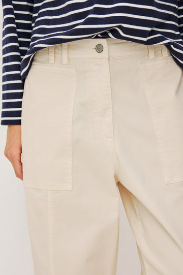 Lunar Pant in Stretch Corduroy With Relaxed Straight Legs, Zip-Fly Closure, Belt Loops, Seam Detailing, Carpenter-Style Side Pockets, and Back Pockets in Bone Colorway - Lower Body Front Close Up View Featured on Model