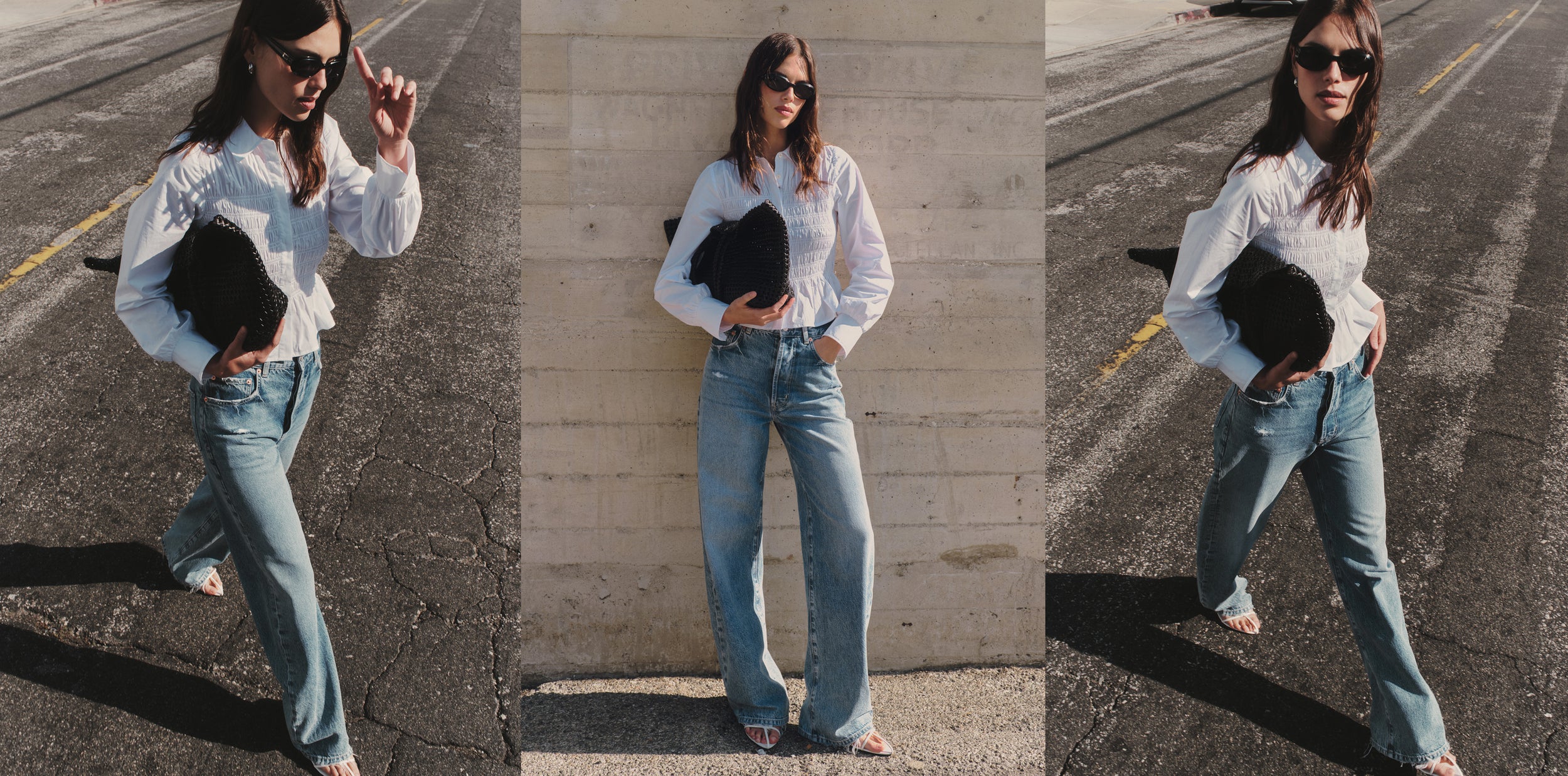Woman in a white shirt and blue jeans holding a black clutch against a neutral background