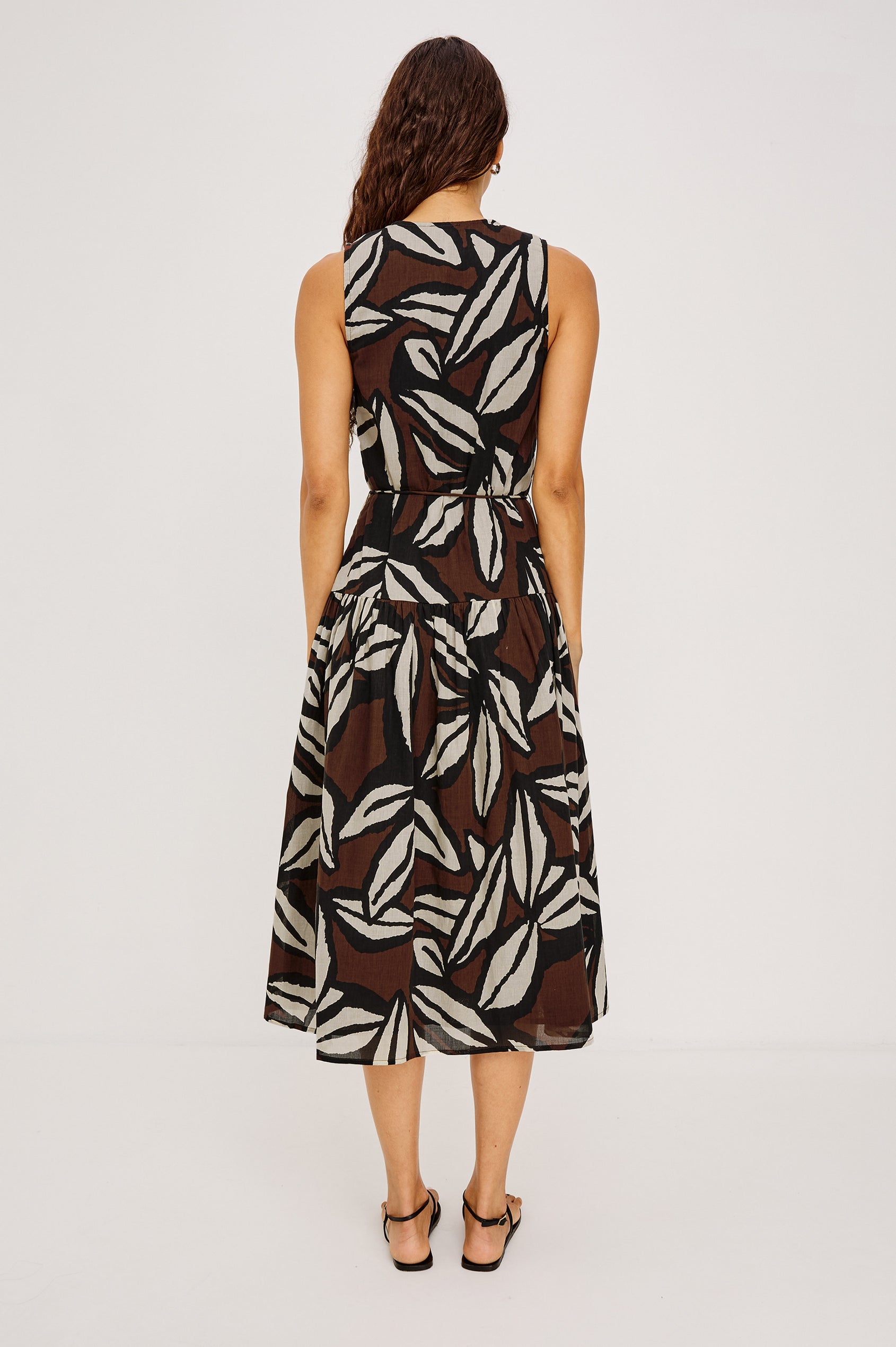 Maeve Midi Dress in Cotton Voile With V-Neckline, Adjustable Belted Ties, A-Line Silhouette, Drop Waist, Tiered Skirt, and Side Seam Zipper in Cocoa Floral Colorway - Full Body Back View Featured on Model