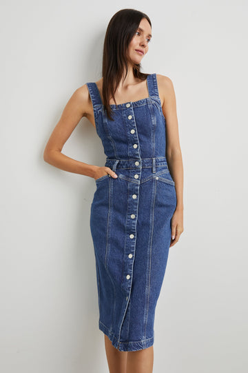 Malibu Sleeveless Denim Midi Dress with Shoulder Straps, Buttons Down the Front, a Square Neckline in the Front and Back, Two Front Pockets and Two Back Patch Pockets in Mazarine Colorway - Front Full Body View Featured on Model