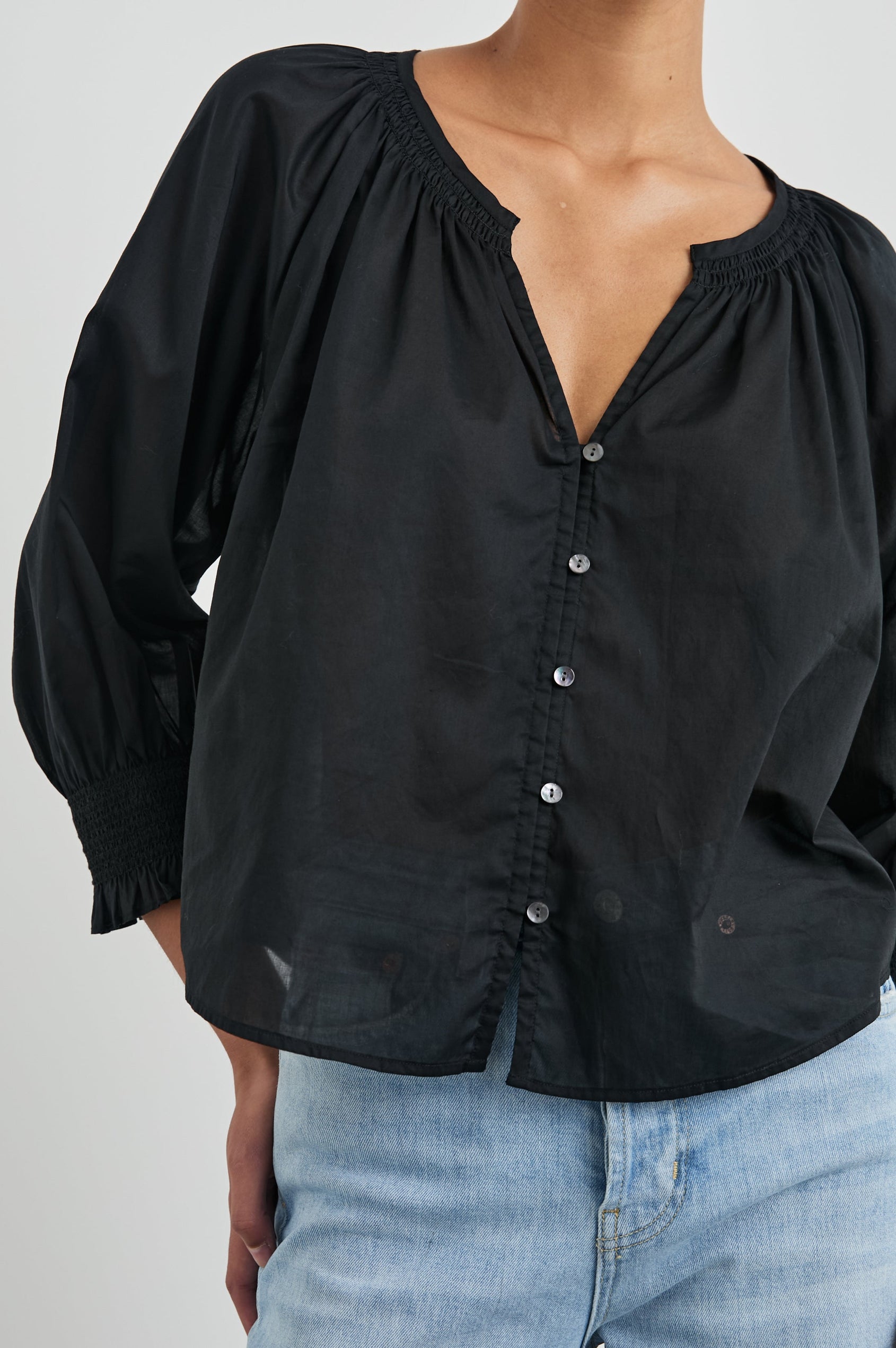 Mariah Top with Three-Quarter Sleeves, Shirred Cuffs, V-Neckline, and Buttons Down the Front in Black Colorway - Front View Featured on Model  