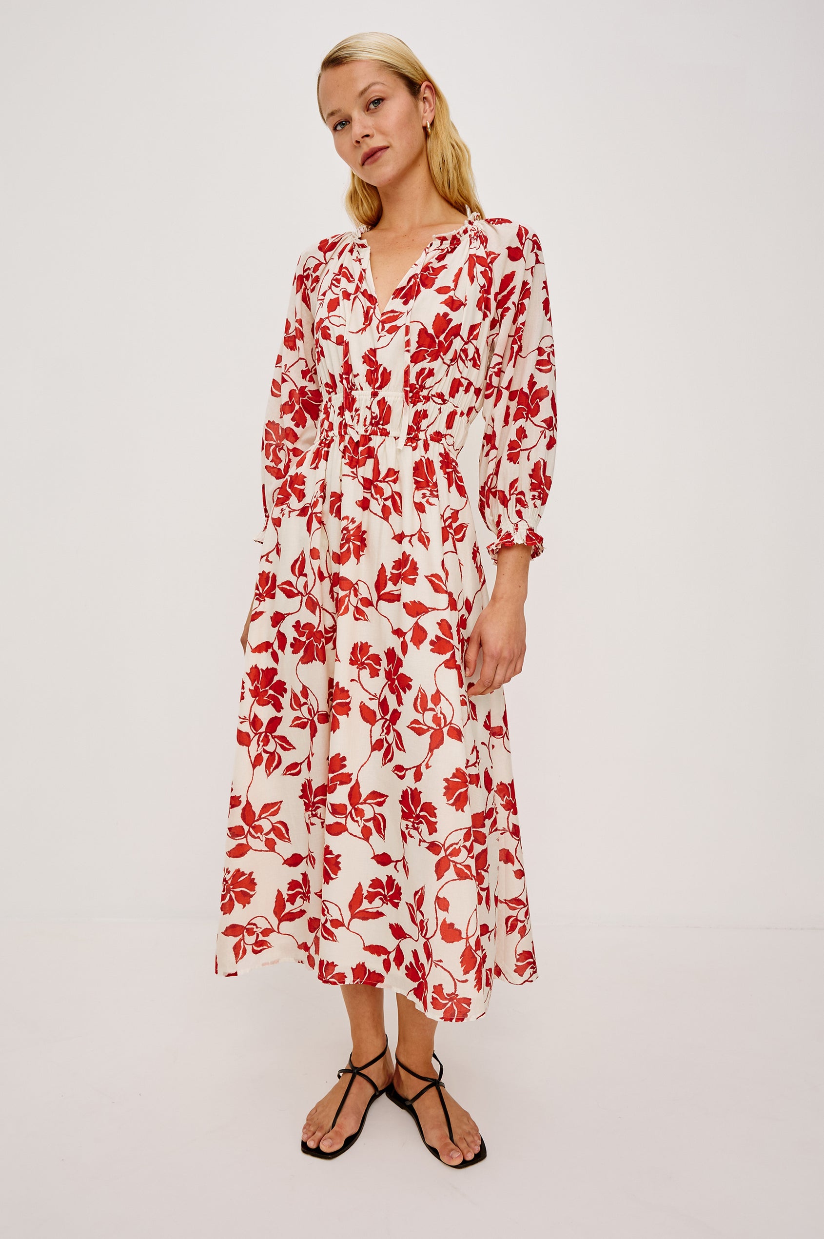 Matia Maxi Dress in Cotton With Banded Ruffle V-Neckline With Self-Ties Elastic Waist and Long Raglan Puff Sleeves in Red Jasmine Colorway - Full Body Front View Featured on Model