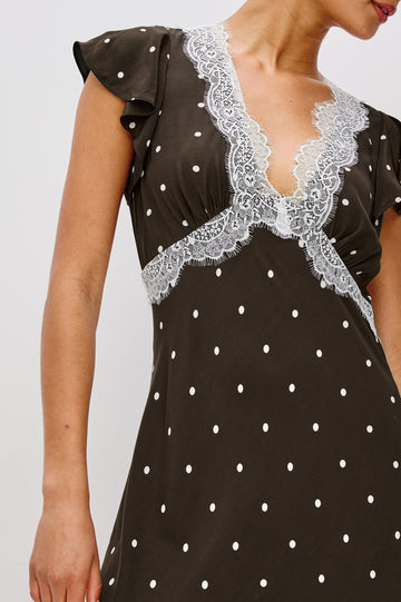 A flowing cocoa polka-dot maxi dress in crepe. The dress has a lace-trimmed V-neckline, ruffle cap sleeves, a hidden side zipper, and godet inserts that add movement to the skirt. Close Up View featured on Model.