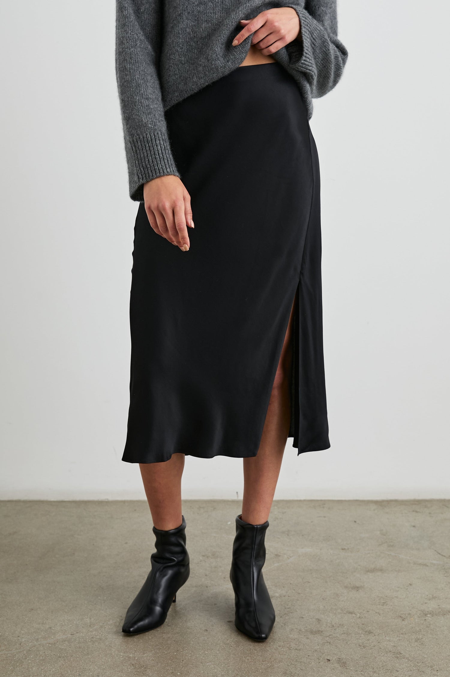 Maya Midi Skirt with Mid-Thigh Side Slit in Black Colorway - Front View Featured on Model
