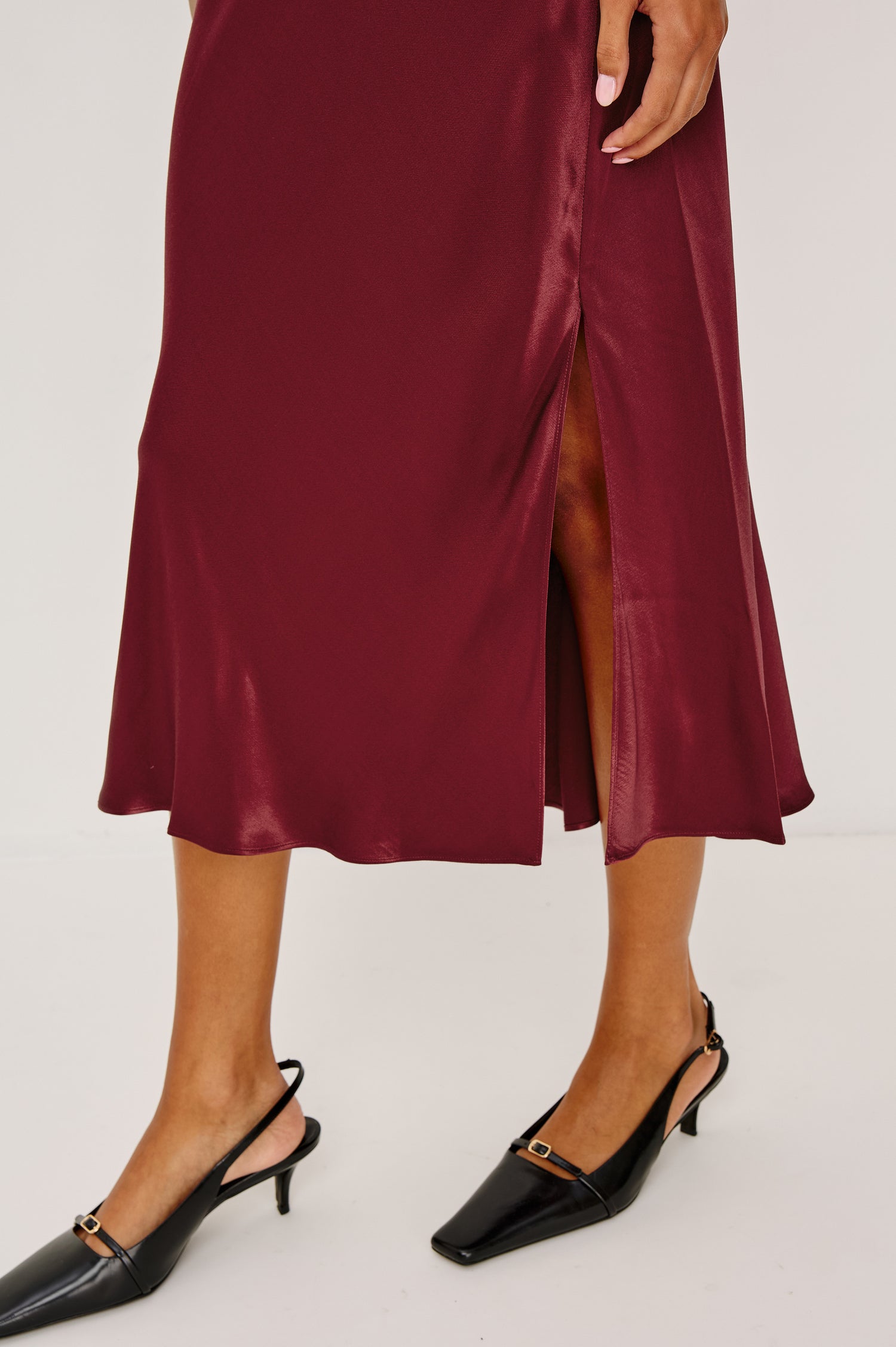 Maya Midi Skirt in Satin Back Crepe With Mid-Thigh Side Slit in Garnet Colorway - Lower Body Side View Featured on Model