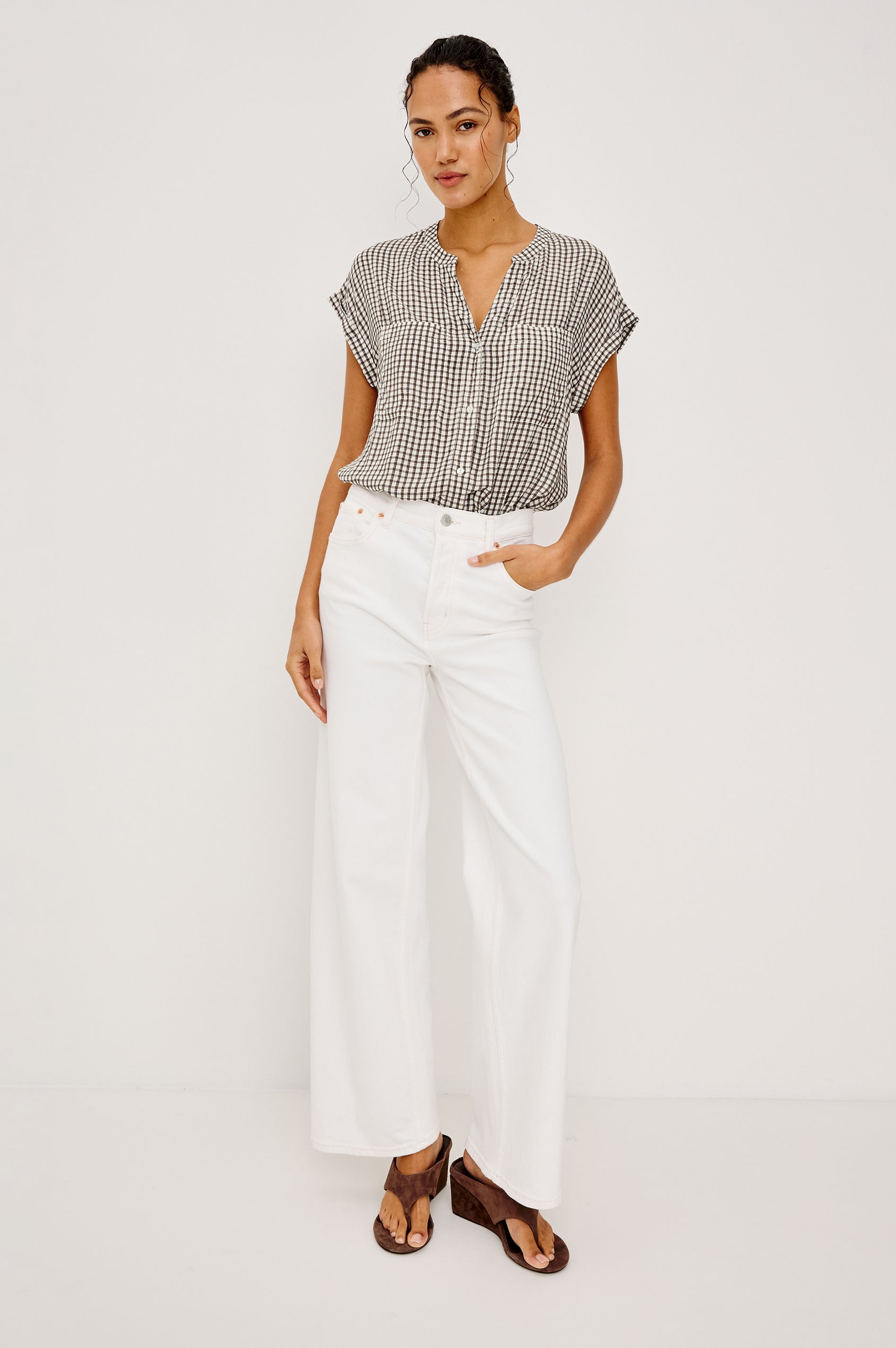 Mel Boxy Button-Up Shirt With Ruffled Cap Sleeves Banded V-Neckline Front Buttons Chest Patch Pockets and Curved High Neckline in Espresso Gingham - Full Body Front View Featured on Model