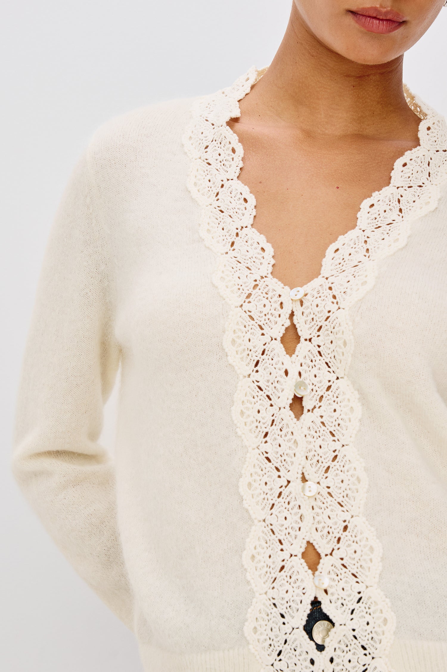 Mer Relaxed Fit Knit Cardigan in Soft Alpaca-Wool Brand With a V-Neckline, Lace Trim, Front Button Closures, and Long Sleeves in Ivory Colorway - Upper Body Close Up View Featured on Model