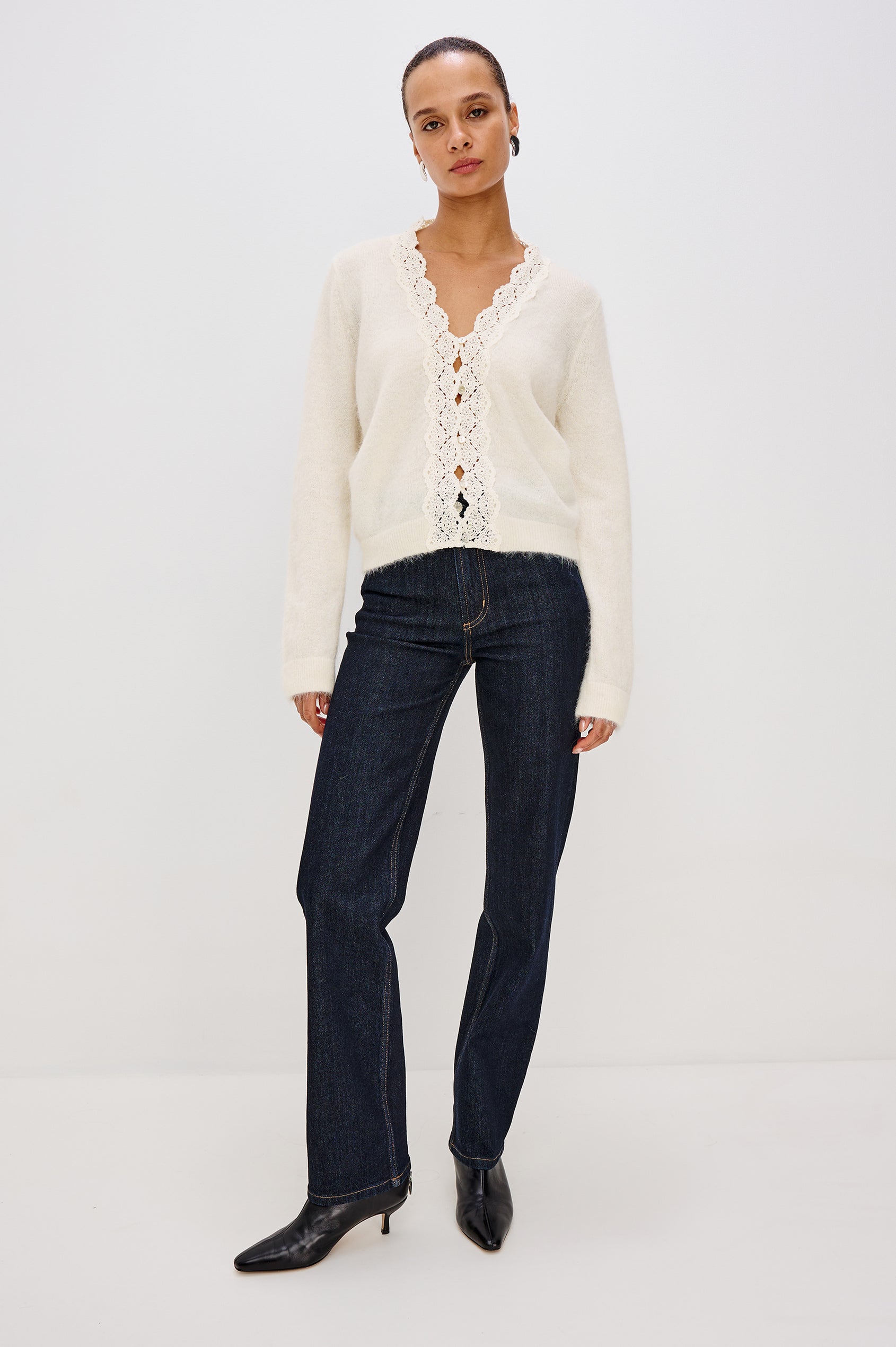 Knitted from a soft alpaca-wool blend, the Mer features a flattering V-neckline trimmed with delicate lace extending to the hem. With front button closures and long sleeves. Full Front View featured on Model.