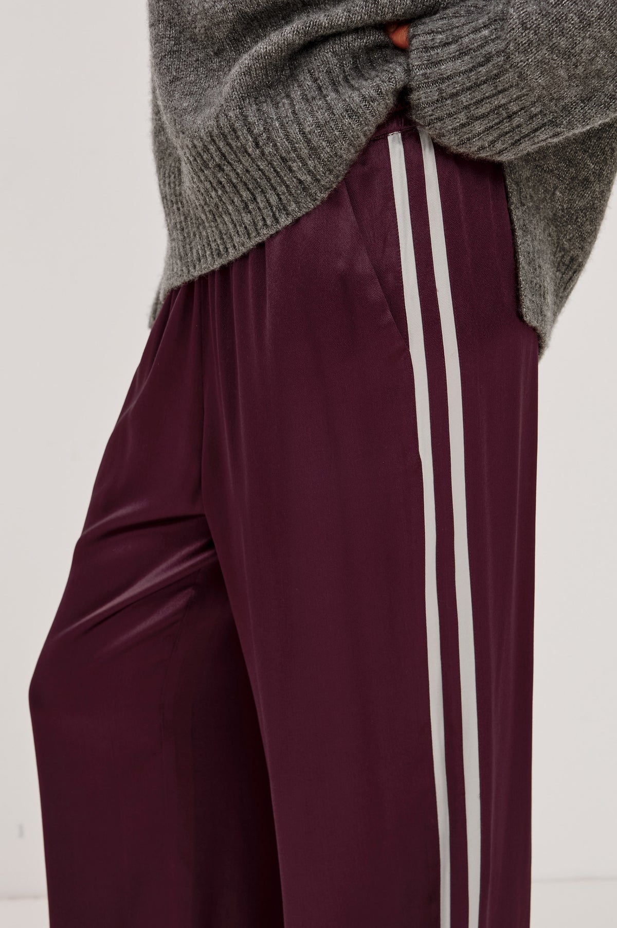 Merida Pant in Satin Back Crepe With Elastic Waistband, Side Pockets, and Wide Legs With Double Side Stripes in Wine Colorway - Lower Body Close Up Side View Featured on Model