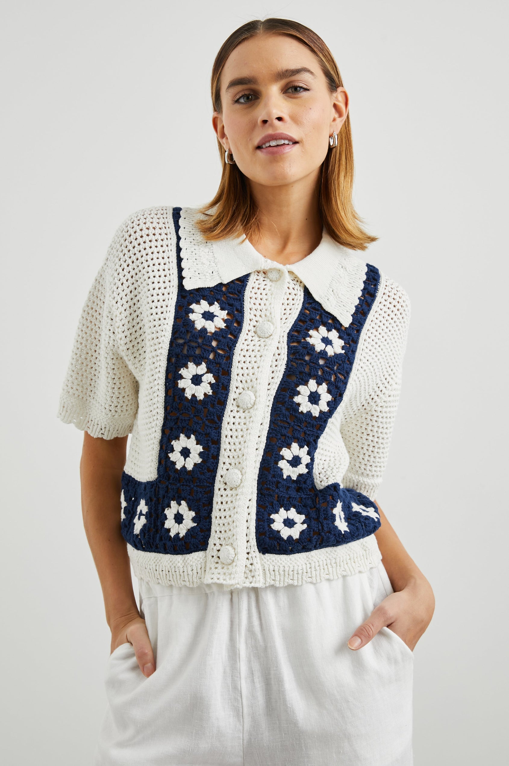 Milan Short-Sleeve Crochet Top with Front Button Closure and a Collar in Navy Crochet Daisies Colorway, White Daisies on a Navy Border on White - Front View Featured on Model 