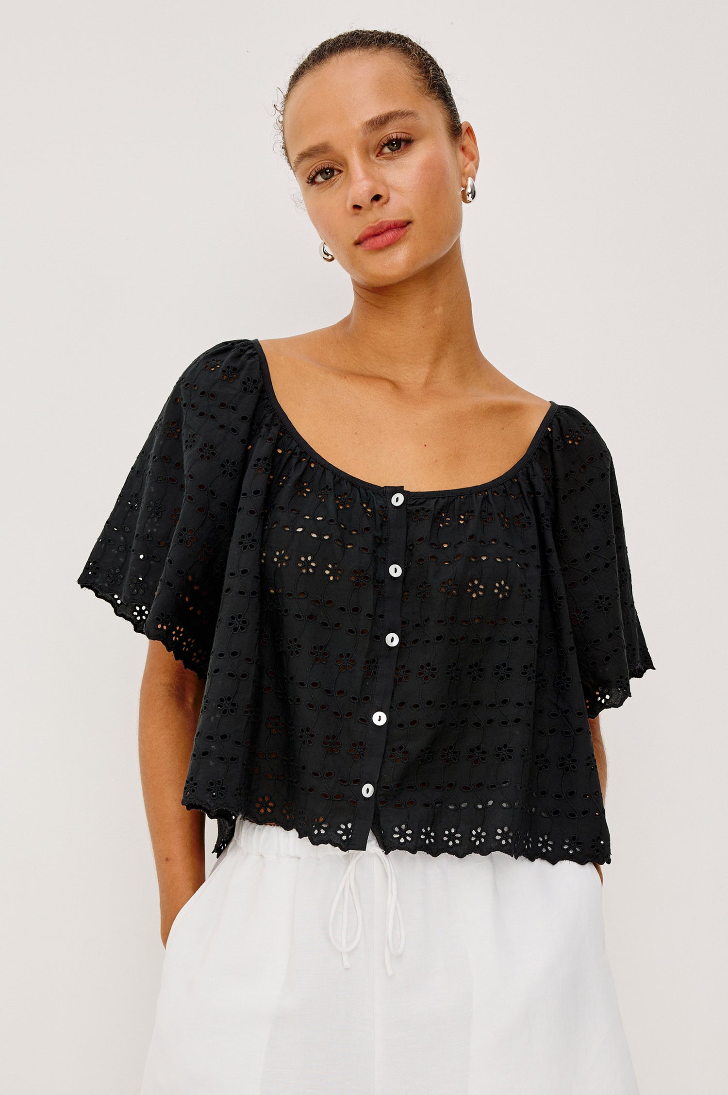 Miller Top in Cotton Voile With Cropped Fit, Wide Short Sleeves, Scoop Neck, Front Buttons, and No Lining in Black Eyelet Colorway - Upper Body Front View Featured on Model