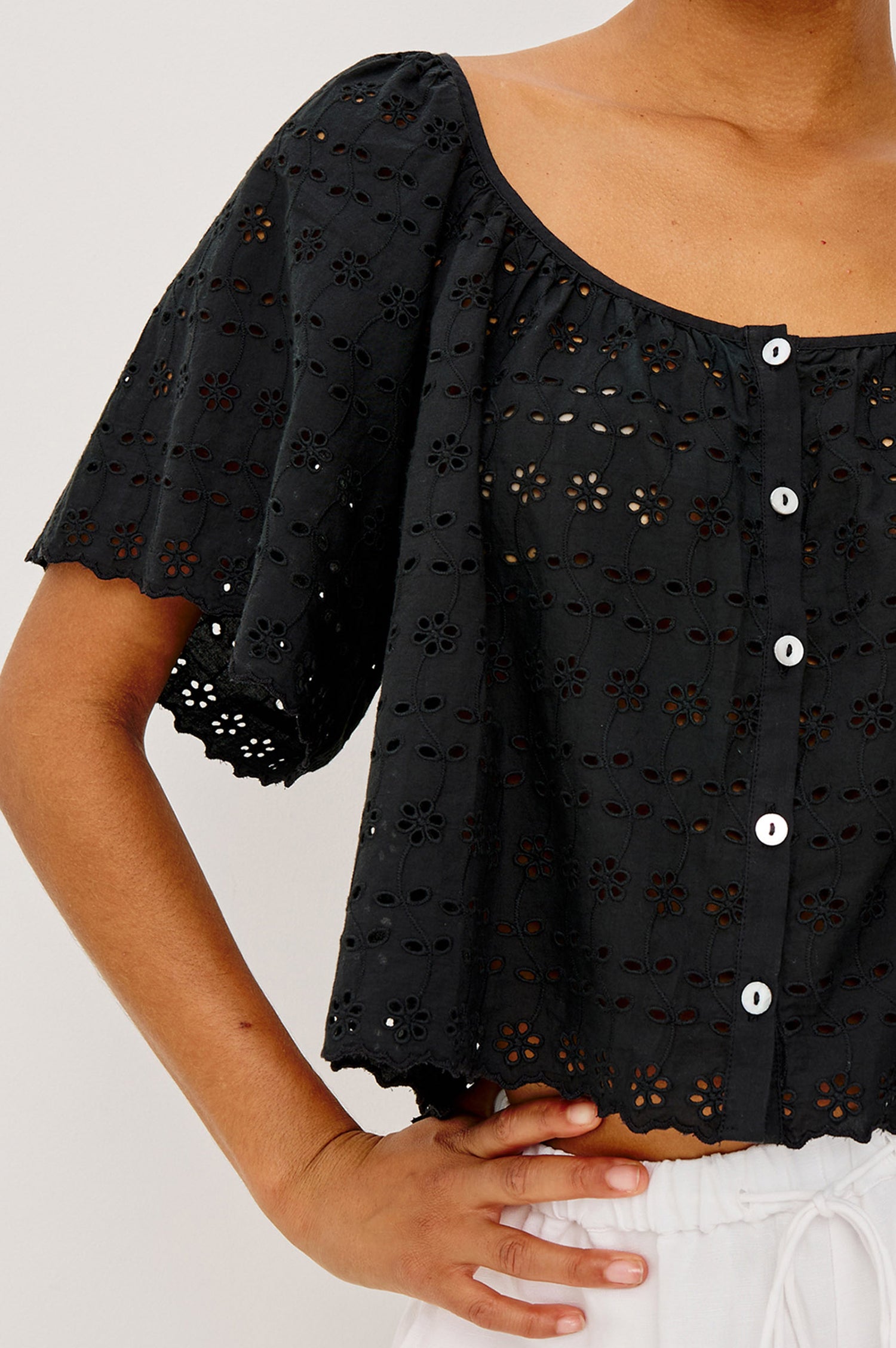 Miller Top in Cotton Voile With Cropped Fit, Wide Short Sleeves, Scoop Neck, Front Buttons, and No Lining in Black Eyelet Colorway - Upper Body Front View Featured on Model