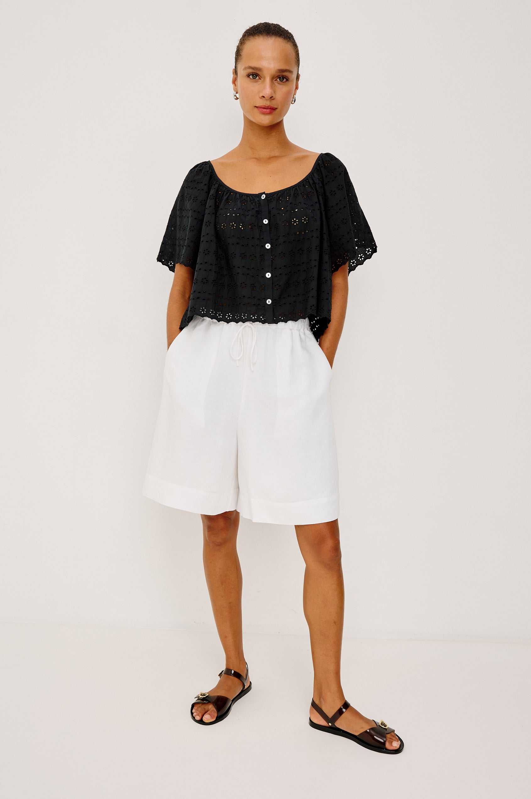 Miller Top in Cotton Voile With Cropped Fit, Wide Short Sleeves, Scoop Neck, Front Buttons, and No Lining in Black Eyelet Colorway - Upper Body Front View Featured on Model