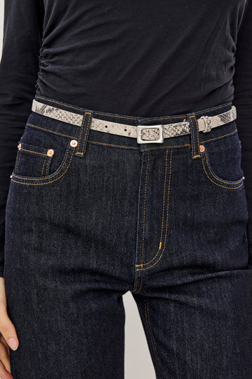 Remi Slim Leather Belt With Adjustable Buckle Closure in Ecru Python Colorway - Close Up Front Mid Body View Featured on Model