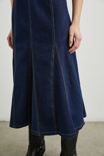 Minna Sleeveless Denim Midi Dress with Shoulder Straps, a Scoop Neck, Darting Details, and a Half Zippered Back in Rinse Indigo Colorway - Front View Featured on Model   