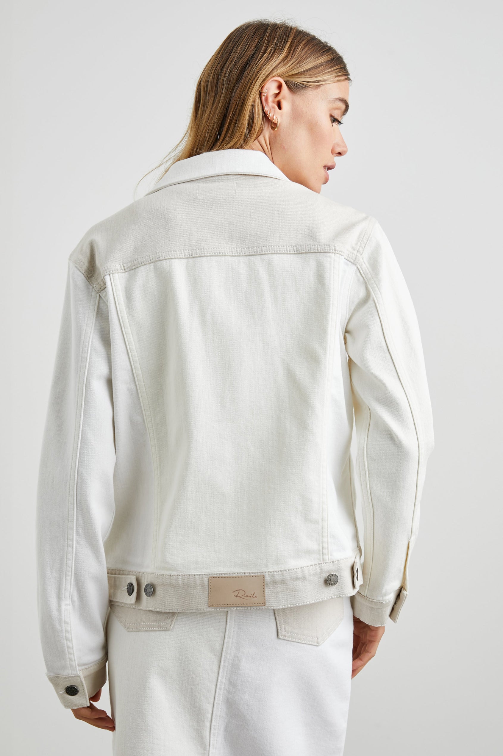 Mulholland Denim Jacket with Button Closure, Two Chest Button Flap Pockets, Two Front Pockets, Adjustable Button Straps on Hem in Ecru Patchwork Colorway, Patches of Neutral Colors - Back View Featured on Model  