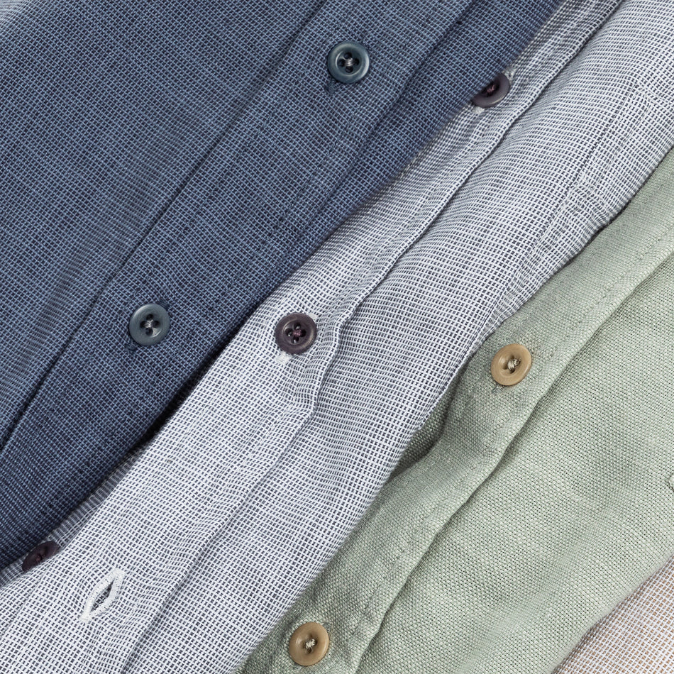 CLOSE UP IMAGE OF THREE BUTTON DOWN SHIRTS SHOWING THE FRONT BUTTONS