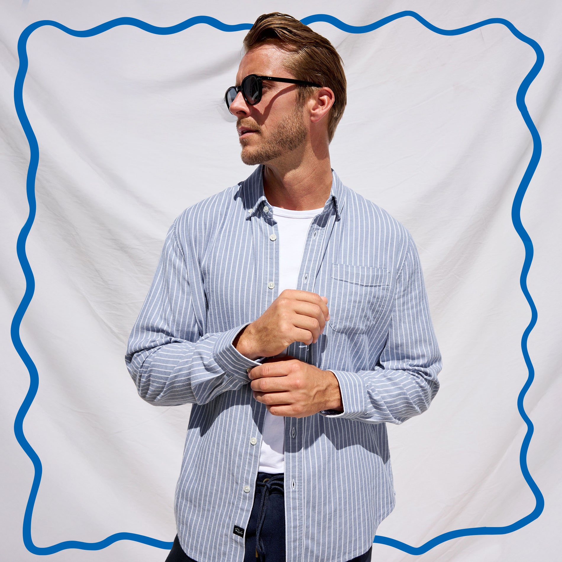 Man wearing a striped shirt and sunglasses against a white background