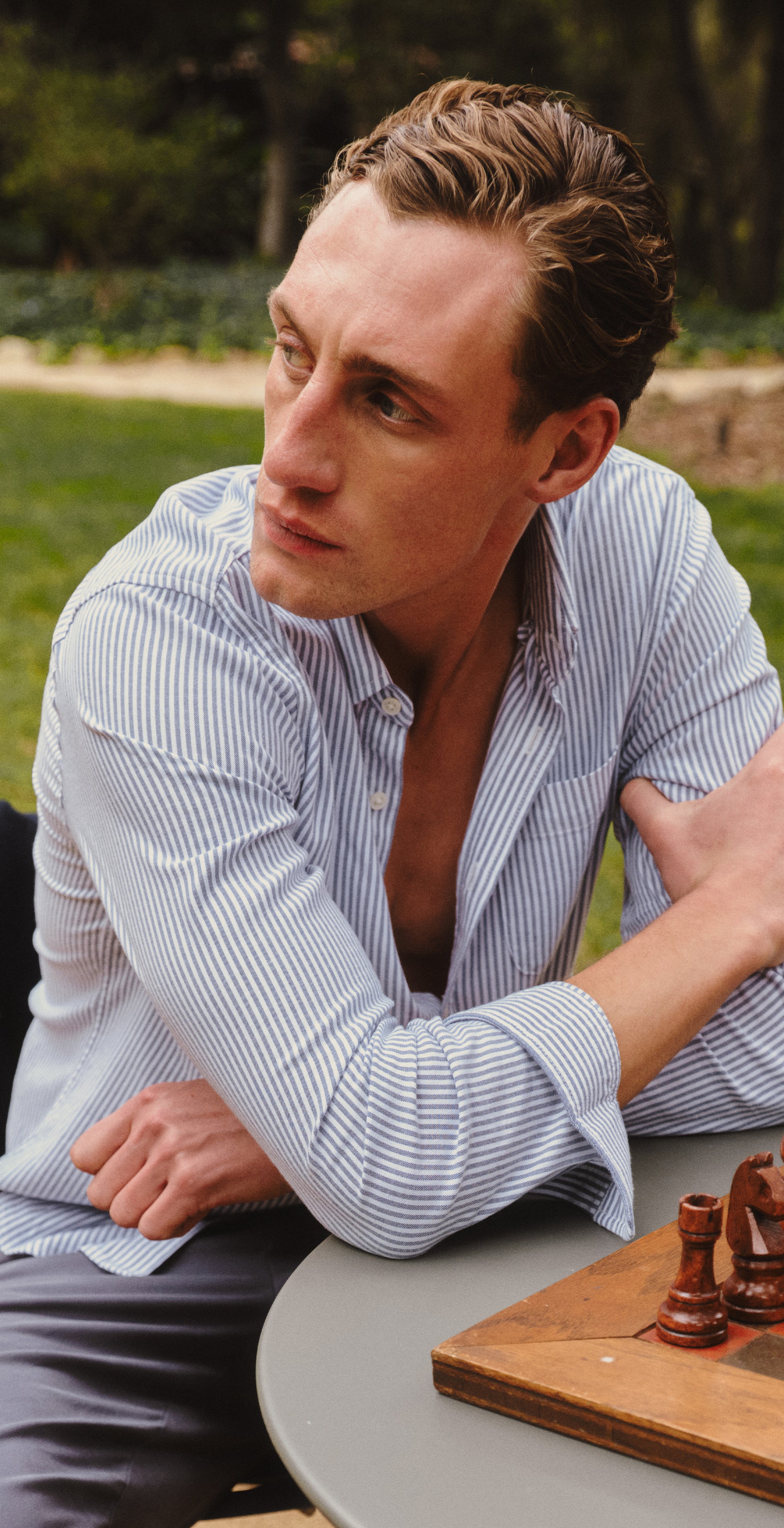 Man playing chess outdoors with a scenic background