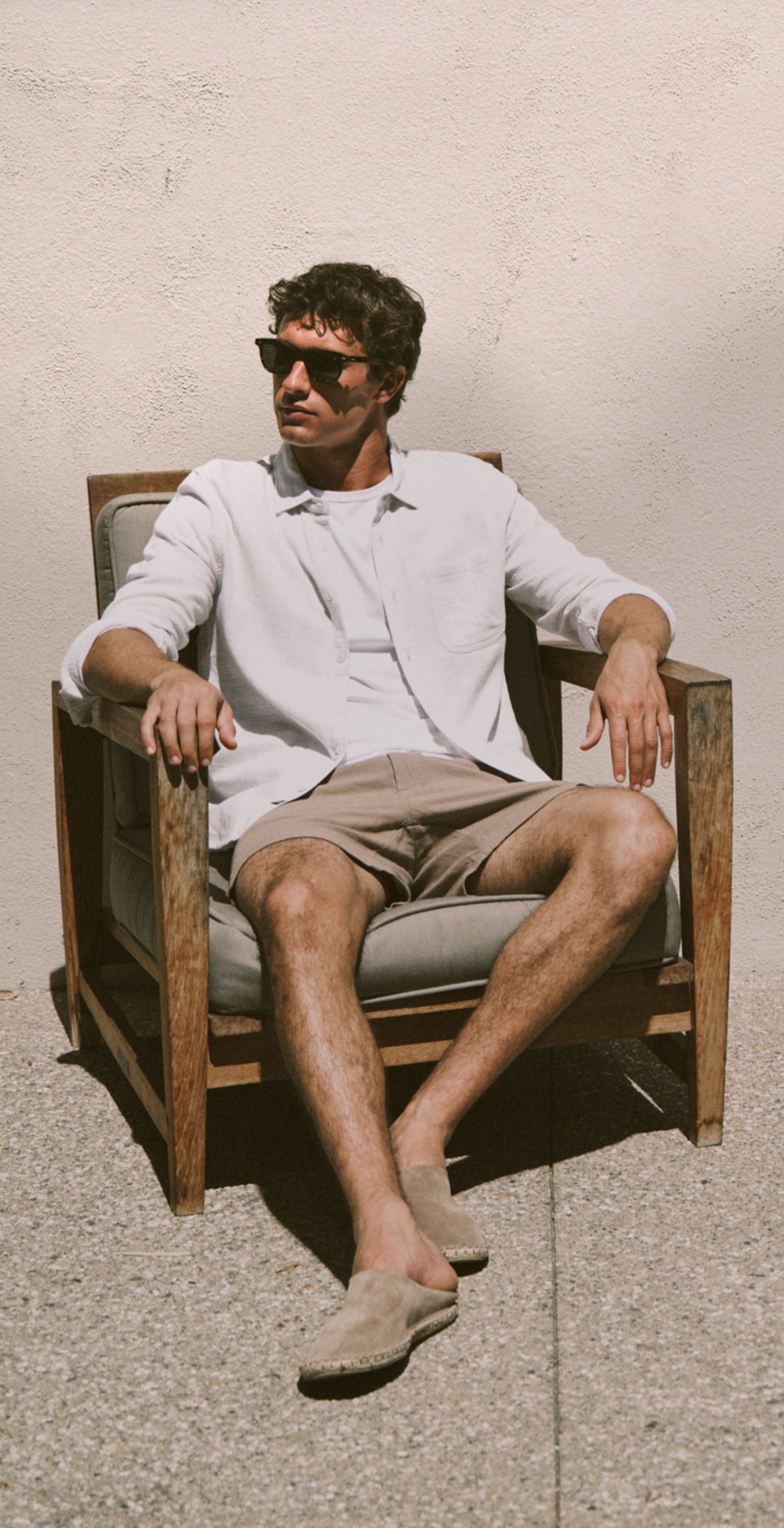 Man wearing a white shirt and brown shorts 