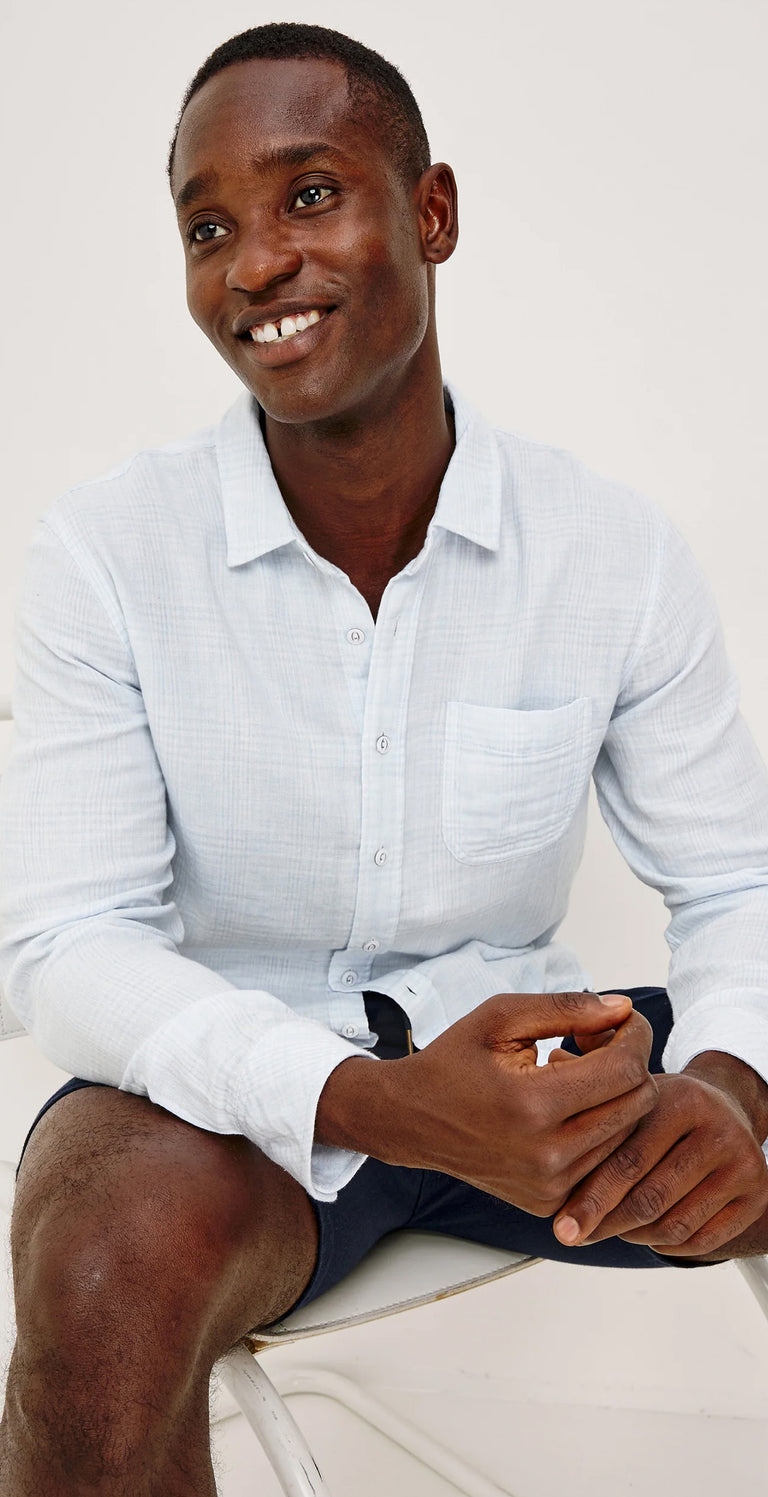 Three images of a man wearing a light blue shirt and blue shorts against a white background.