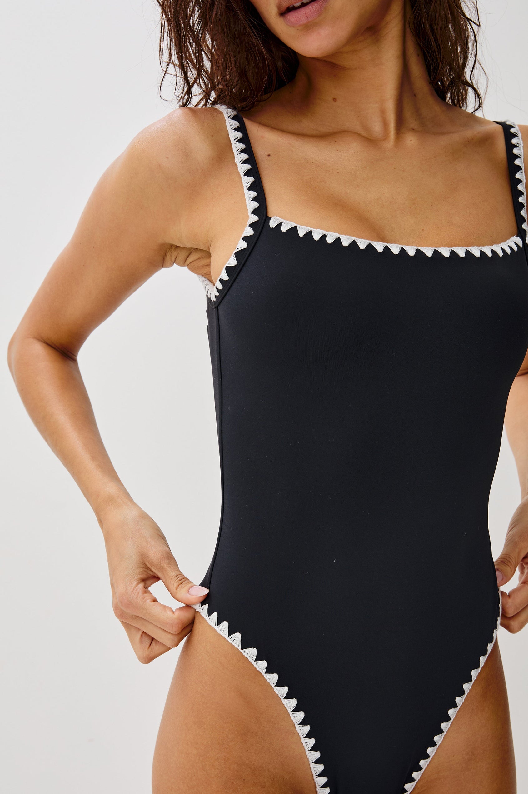 Nadia Scoop Front One Piece Bathing Suit with Adjustable Straps, Low Back, High Leg, Classic Coverage and Contrast White Blanket Stitch at Seams. Front Detailed View Shown on Model.