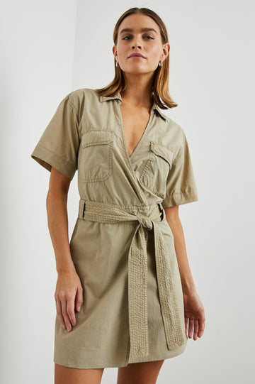 Natalie Short Sleeve Mini Dress with a Deep V Neck, Fabric Tie Belt, Belt Loops, Two Chest Flap Pockets, Buttoned Horizontal Flap on the Back and a Collar in Olive Colorway - Front View Featured on Model 